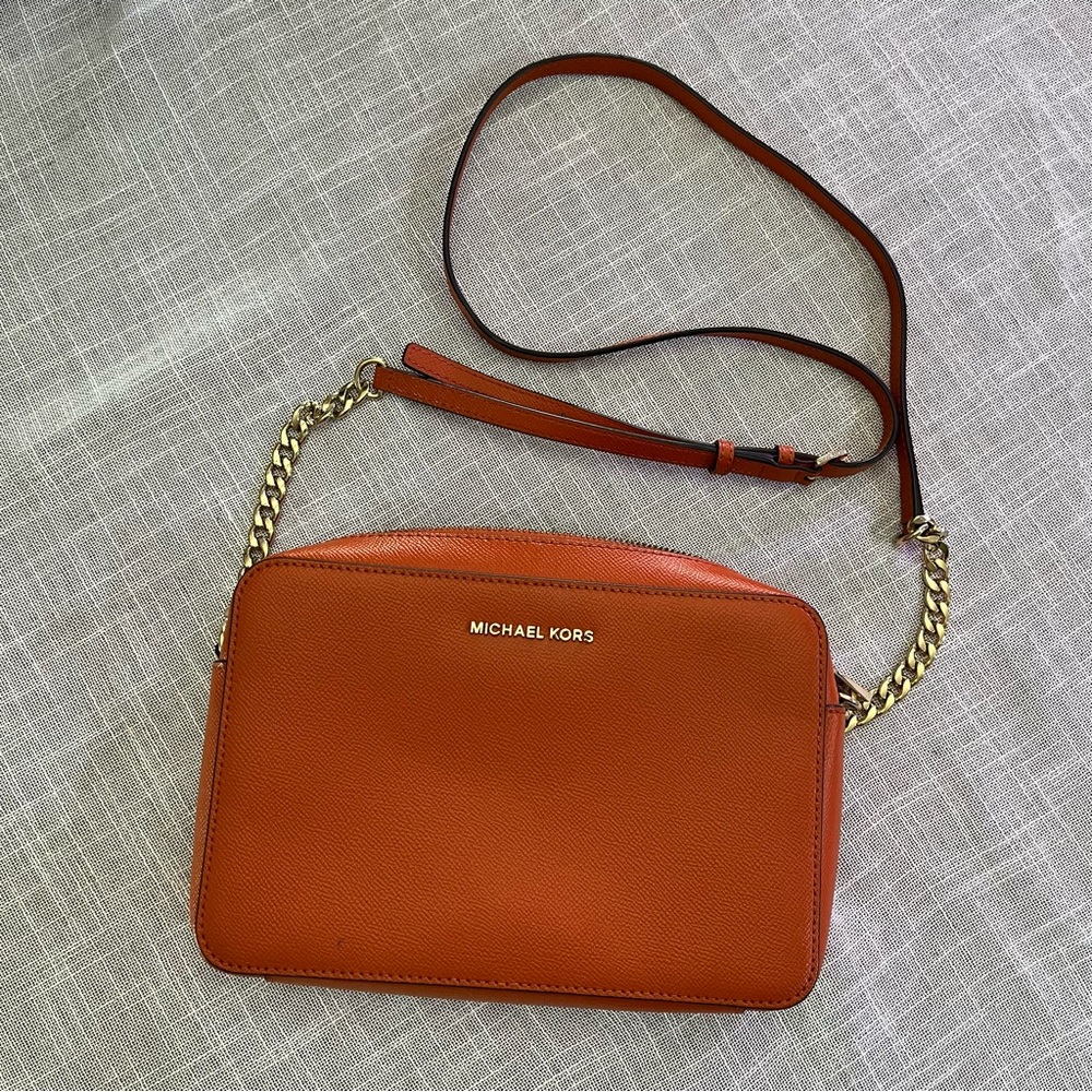 Michael Kors Women's Jet Set Large Crossbody Bag in an orange color.